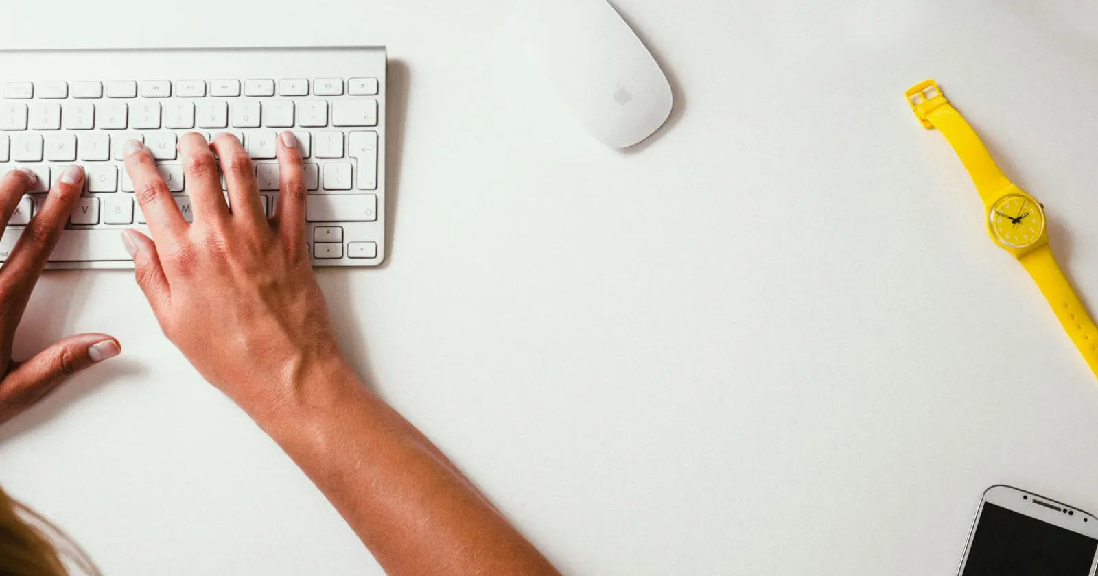 Picture of a woman typing on a keyboard at a desk